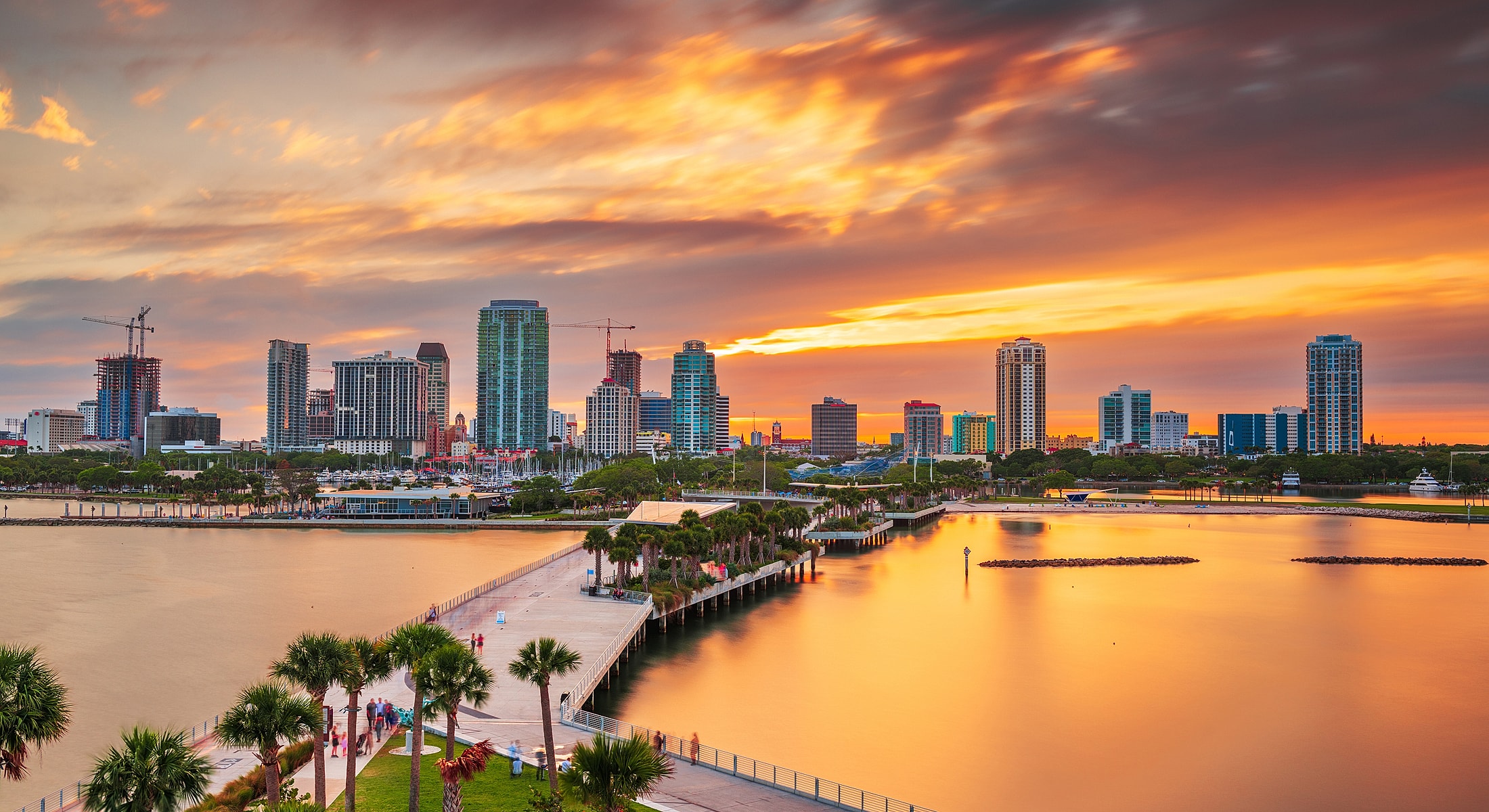 Downtown skyline at sunset with water reflections.